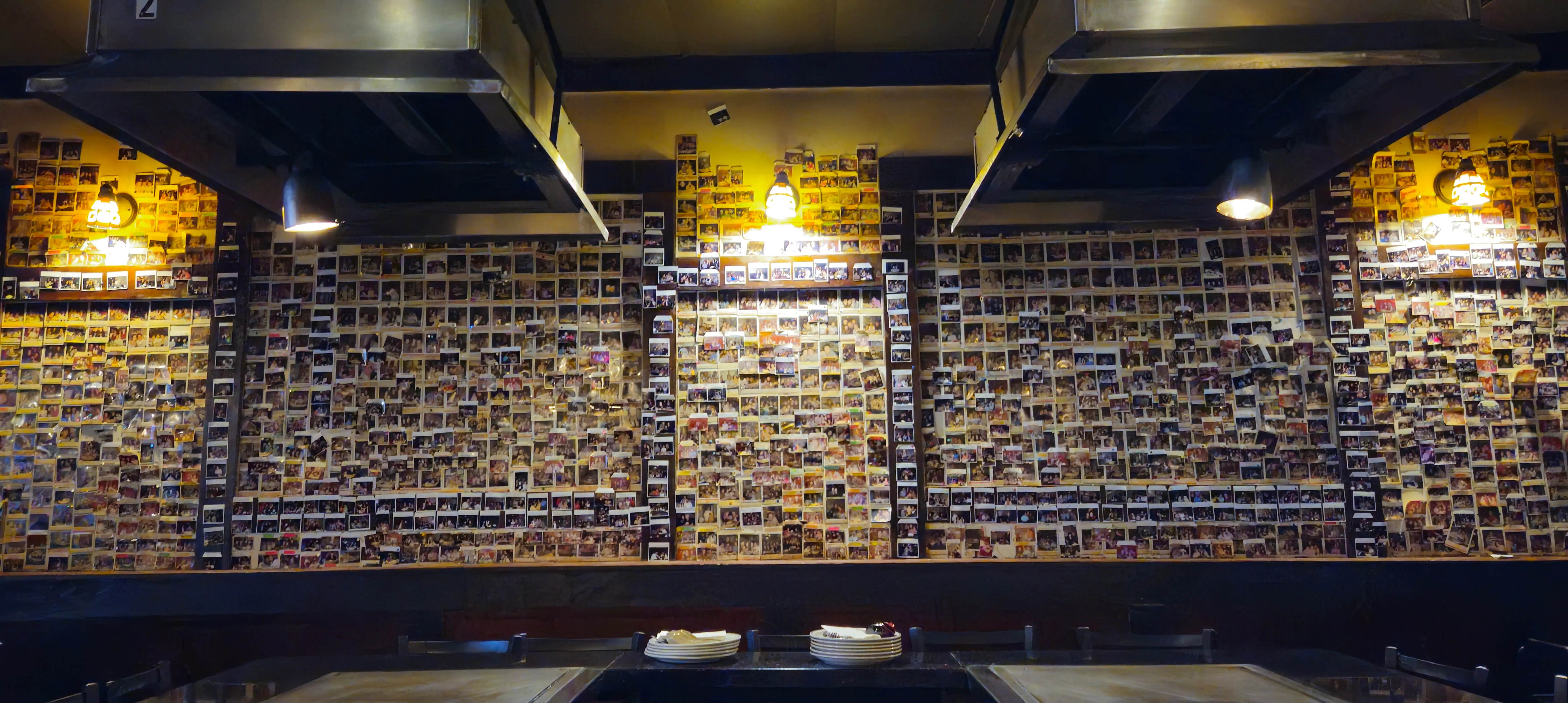 Display of polaroid pictures on the restaurant walls of past happy customers