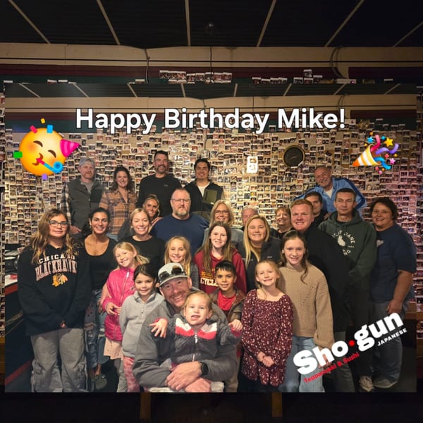 A large group of people, including adults and children, celebrating a birthday at Shogun Japanese Steakhouse.