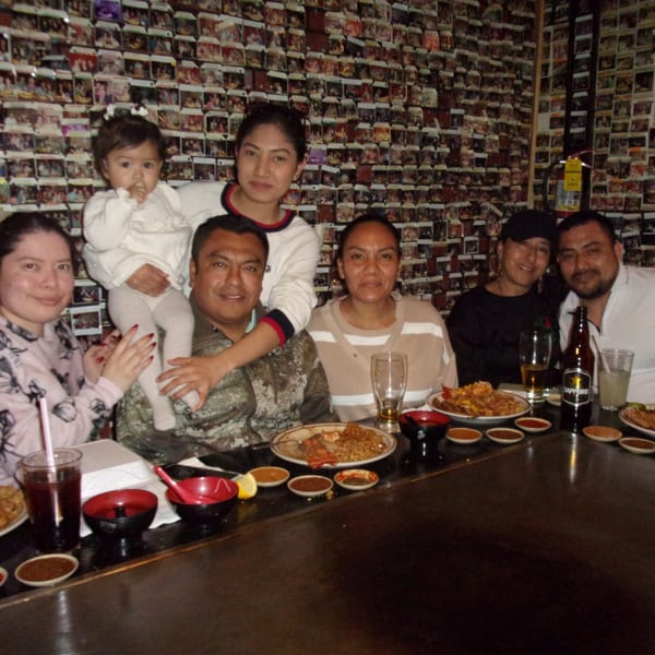A family of seven, including a baby, enjoying a hibachi meal at Shogun Japanese Steakhouse.