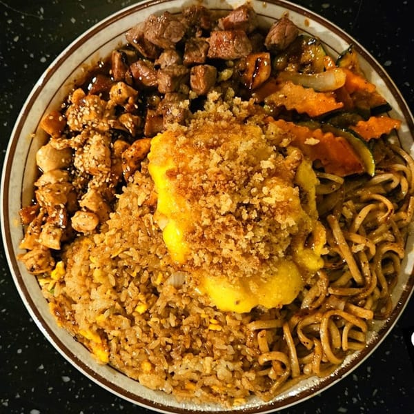 A hibachi dinner plate with steak, chicken, fried rice, noodles, and vegetables.
