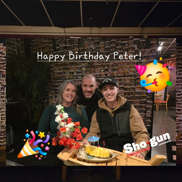 Three smiling people celebrating a birthday at Shogun Japanese Steakhouse, with pineapple dessert.